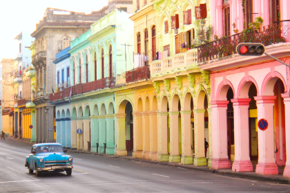 Classic old cars and traditional colorful buildings in downtown Havana, Cuba